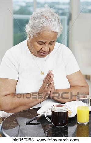 Senior African American woman saying grace View Large Photo Image Stock Image - Senior African American woman saying grace. Fotosearch