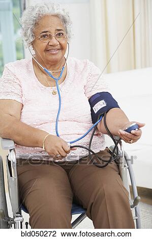 Senior African American woman taking own blood pressure View Large Photo Image Stock Image - Senior African American woman taking own blood pressure. Fotosearch