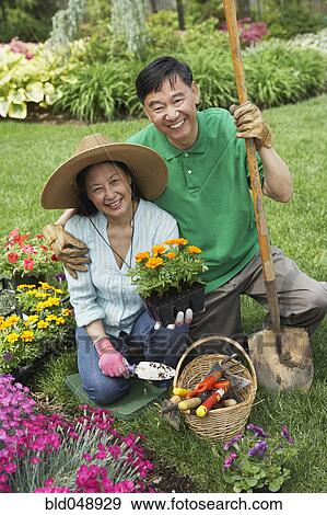 Stock Photo - Senior Asian couple gardening. Fotosearch