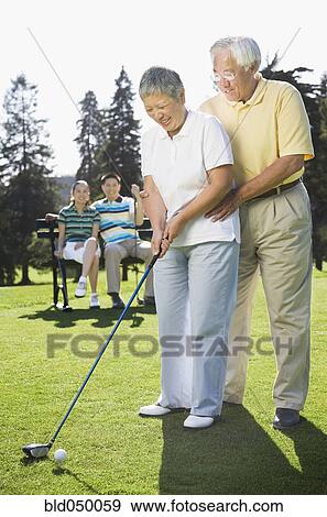 Senior Asian couple playing golf View Large Photo Image Stock Photo - Senior Asian couple playing golf. Fotosearch