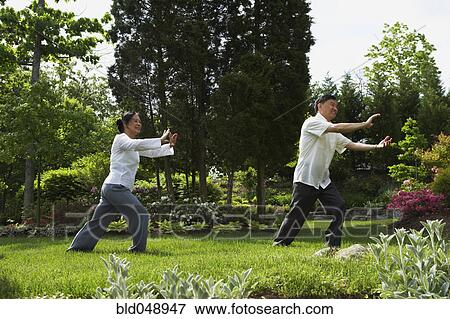 Stock Photo - Senior Asian couple practicing tai chi. Fotosearch