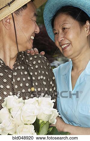 Stock Image - Senior Asian couple smiling at each other. Fotosearch