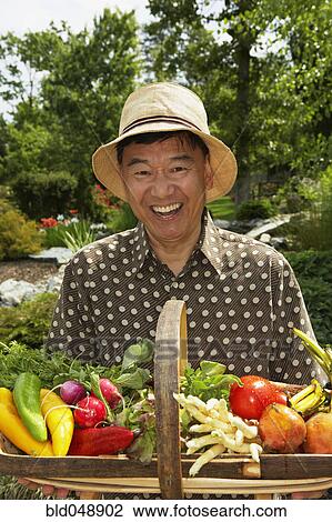 Senior Asian man holding basket of vegetables View Large Photo Image Stock Image - Senior Asian man holding basket of vegetables. Fotosearch