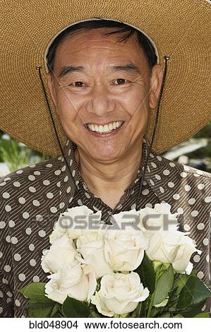 Senior Asian man holding flowers View Large Photo Image Picture - Senior Asian man holding flowers. Fotosearch