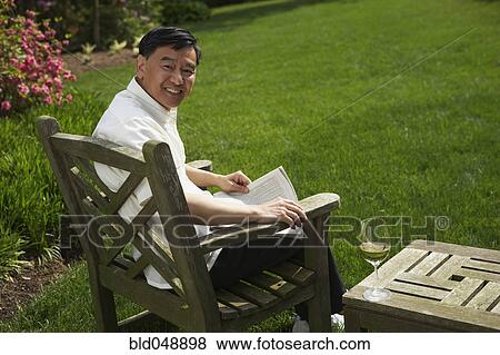 Senior Asian man reading in backyard View Large Photo Image Stock Photo - Senior Asian man reading in backyard. Fotosearch