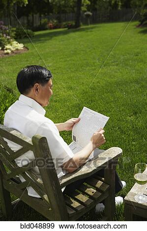 Senior Asian man reading in backyard View Large Photo Image Stock Photo - Senior Asian man reading in backyard. Fotosearch