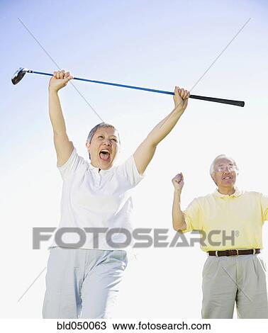 Senior Asian woman cheering with golf club View Large Photo Image Stock Image - Senior Asian woman cheering with golf club. Fotosearch