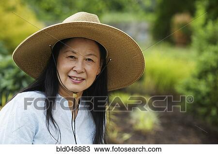 Stock Image - Senior Asian woman wearing hat. Fotosearch