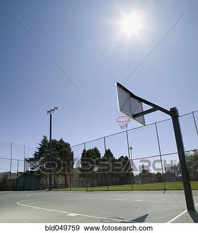 Stock Photo - Sun shining on basketball court. Fotosearch
