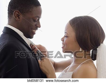 African bride adjusting groom’s necktie View Large Photo Image Stock Image - African bride adjusting groom’s necktie. Fotosearch