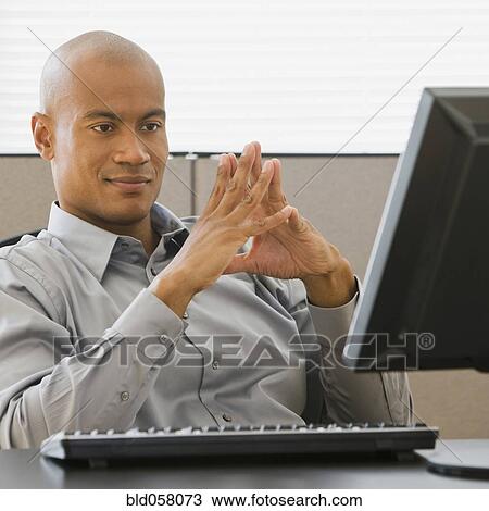 African businessman looking at computer View Large Photo Image Stock Image - African businessman looking at computer. Fotosearch