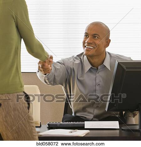 Stock Image - African businessman shaking hands with client. Fotosearch