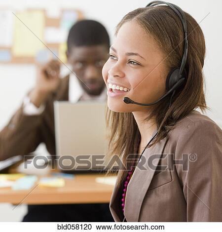 Stock Image - African businesswoman wearing headset. Fotosearch