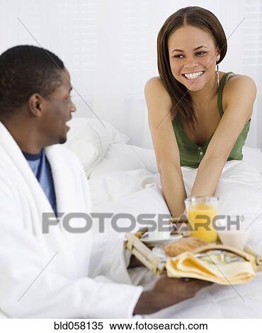 African couple eating breakfast in bed View Large Photo Image Stock Photography - African couple eating breakfast in bed. Fotosearch
