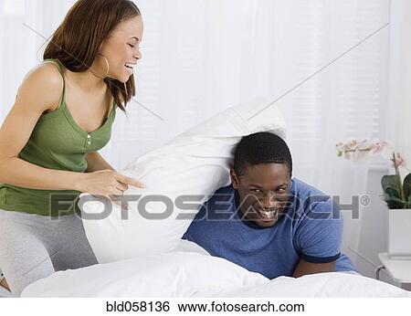 African couple having pillow fight View Large Photo Image Stock Photograph - African couple having pillow fight. Fotosearch