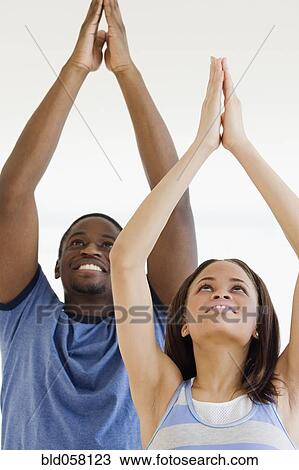 Stock Image - African couple practicing yoga. Fotosearch