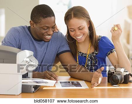 Stock Photo - African couple printing out photographs. Fotosearch