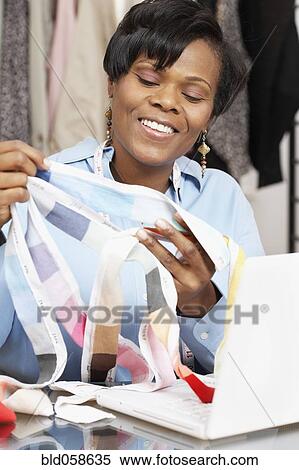 Stock Photography - African fashion designer holding fabric swatches. Fotosearch