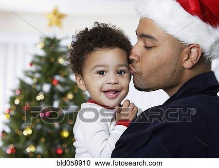 Stock Image - African father kissing baby. Fotosearch