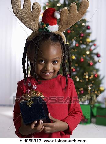 African girl holding Christmas gift View Large Photo Image Stock Photo - African girl holding Christmas gift. Fotosearch