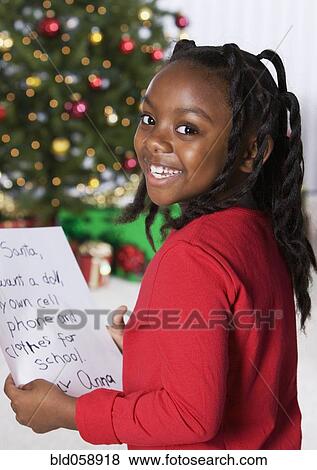 Stock Photo - African girl holding letter for Santa Claus. Fotosearch