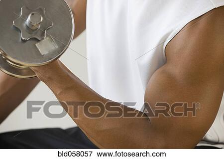 Stock Photo - African man lifting dumbbell. Fotosearch