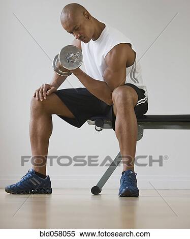 Stock Photography - African man lifting dumbbell. Fotosearch