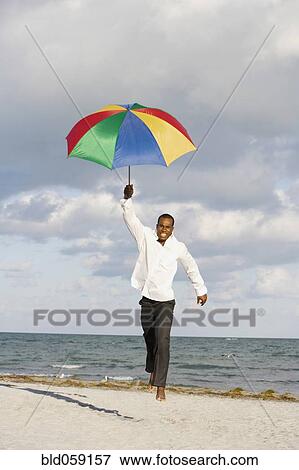 African man running with beach umbrella View Large Photo Image Stock Photo - African man running with beach umbrella. Fotosearch