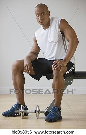 African man sitting on weight bench View Large Photo Image Stock Photograph - African man sitting on weight bench. Fotosearch