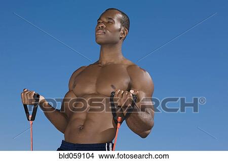 Picture - African man stretching with exercise band. Fotosearch