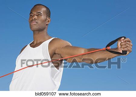 Stock Photo - African man stretching with exercise band. Fotosearch