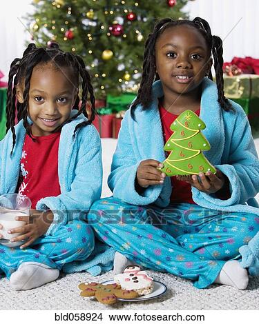 African sisters holding milk and Christmas cookies View Large Photo Image Picture - African sisters holding milk and Christmas cookies. Fotosearch