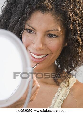 African woman applying lip gloss View Large Photo Image Stock Image - African woman applying lip gloss. Fotosearch