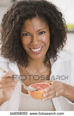 African woman eating grapefruit View Large Photo Image Stock Image - African woman eating grapefruit. Fotosearch