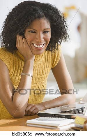 African woman next to laptop View Large Photo Image Stock Photography - African woman next to laptop. Fotosearch