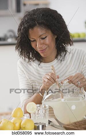 Stock Photography - African woman pouring lemonade. Fotosearch