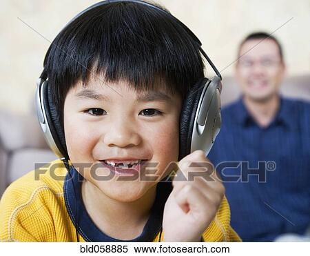 Asian boy listening to headphones View Large Photo Image Stock Photography - Asian boy listening to headphones. Fotosearch