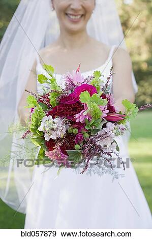 Asian bride holding bouquet View Large Photo Image Stock Photo - Asian bride holding bouquet. Fotosearch