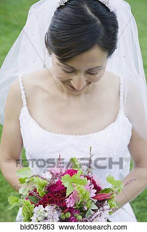 Asian bride looking at bouquet View Large Photo Image Stock Image - Asian bride looking at bouquet. Fotosearch