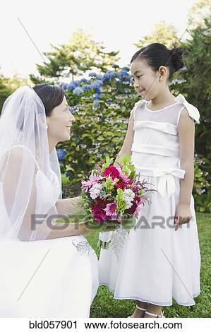 Asian bride smiling at flower girl View Large Photo Image Stock Image - Asian bride smiling at flower girl. Fotosearch
