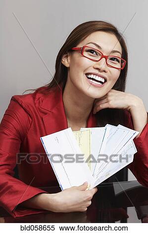 Asian businesswoman holding checks View Large Photo Image Stock Photography - Asian businesswoman holding checks. Fotosearch