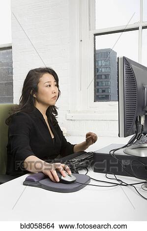 Picture - Asian businesswoman looking at computer. Fotosearch
