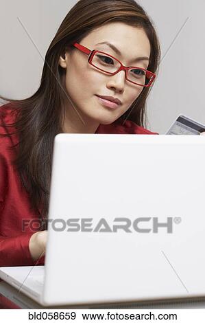 Asian businesswoman shopping online View Large Photo Image Stock Photo - Asian businesswoman shopping online. Fotosearch