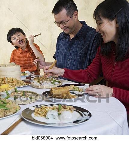 Asian family eating at dinner table View Large Photo Image Picture - Asian family eating at dinner table. Fotosearch