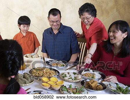 Asian family eating at dinner table View Large Photo Image Stock Image - Asian family eating at dinner table. Fotosearch