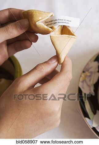 Asian girl opening fortune cookie View Large Photo Image Stock Photo - Asian girl opening fortune cookie. Fotosearch