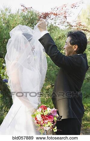 Asian groom lifting bride’s veil View Large Photo Image Stock Photo - Asian groom lifting bride’s veil. Fotosearch