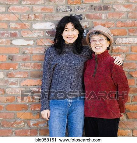 Asian mother and adult daughter hugging View Large Photo Image Stock Image - Asian mother and adult daughter hugging. Fotosearch