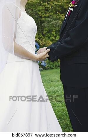 Stock Photo - Asian newlyweds holding hands. Fotosearch