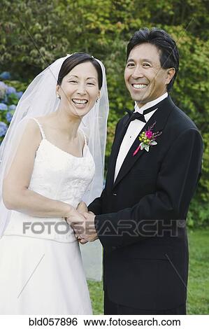 Asian newlyweds holding hands View Large Photo Image Stock Photograph - Asian newlyweds holding hands. Fotosearch